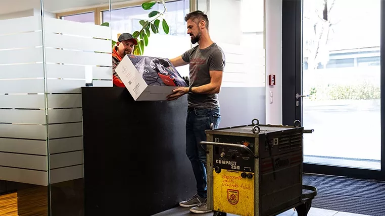 Mann tauscht sein altes Fronius Schweißgerät gegen ein neues Produkt ein.