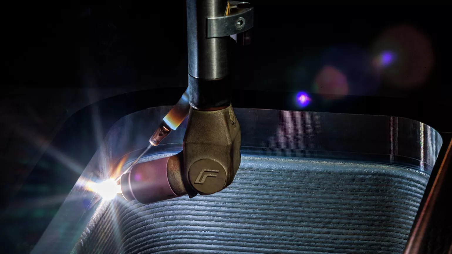 Close-up of a Fronius welding torch during cladding