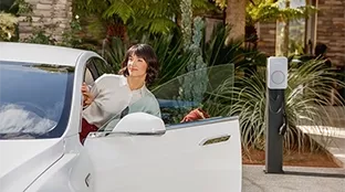 Woman with electric car and Fronius Wattpilot Flex